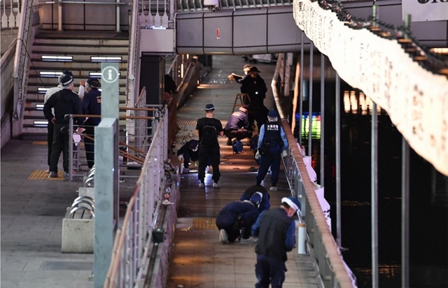 Police in Osaka, Japan examine a bridge in the Namba Parks area where a Vietnamese student was pushed into the Dotonbori River underneath and died. — Mainichi/VNA Photo