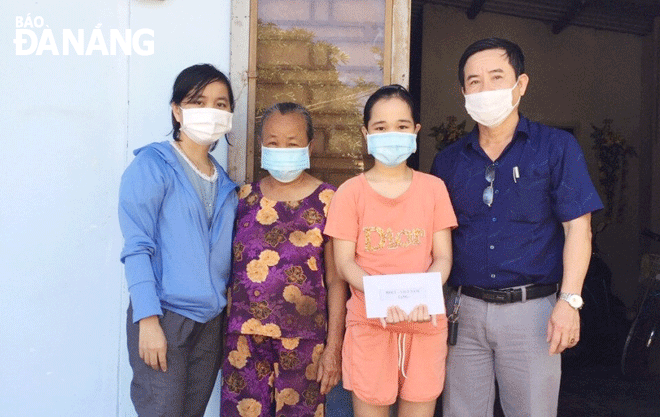 Ông Nguyễn Văn Châu, Giám đốc Trung tâm Công tác xã hội (ngoài cùng, bên phải) trao hỗ trợ cho gia đình trẻ em có hoàn cảnh khó khăn tại xã Hòa Phong, huyện Hòa Vang. Ảnh: THANH THU	