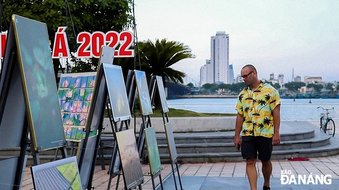 A foreign visitor is delighted with a photo exhibition about the Routers Asia 2022. Photo: THU DUYEN