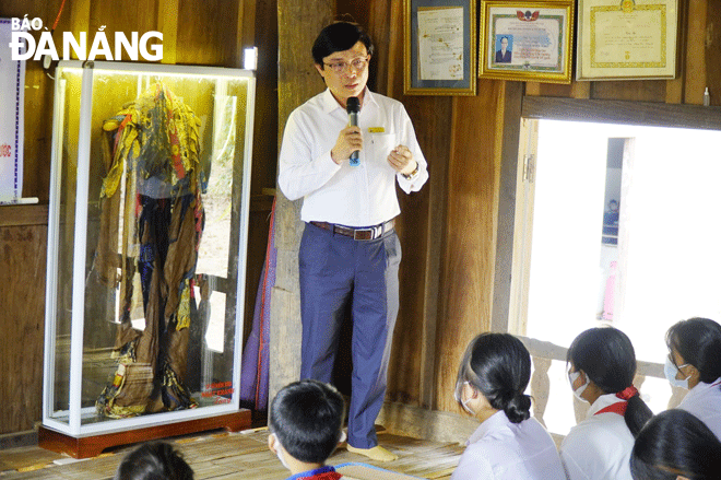 Thầy Nguyễn Mai Trọng trong một lớp ngoại khóa về chiếc áo “Vân phụng tiên y”. Ảnh: TÂN HƯỚNG