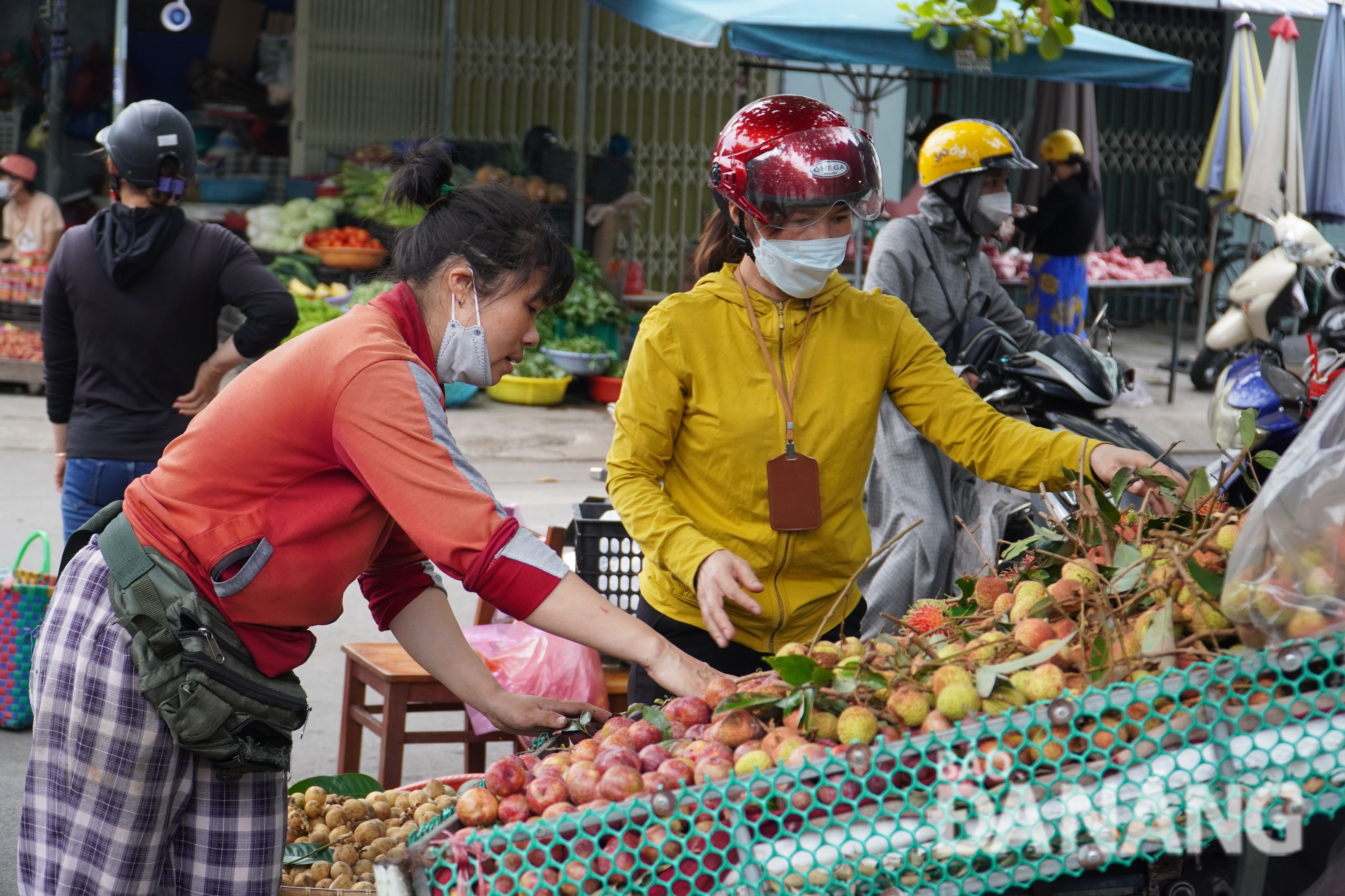 People are seen buying fruits at the Hoa Khanh Market on the morning of June 3.