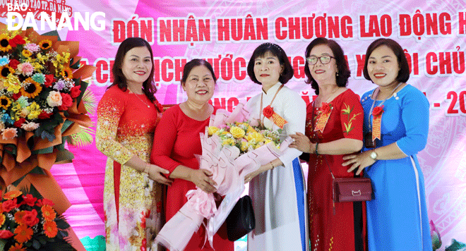 Cô Nguyễn Thị Thực (thứ hai, bên trái sang), Hiệu trưởng Trường Mầm non Hòa Tiến 1 (huyện Hòa Vang) giai đoạn 1990-2006, nhận hoa chúc mừng trong ngày vui của trường.  Ảnh: NHƯ HẠNH