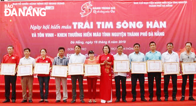 Chị Trà Mỹ Hạnh (thứ 6, trái sang) được tặng bằng khen của Trung ương Hội Chữ thập đỏ Việt Nam năm 2019. Ảnh: LÊ VĂN THƠM