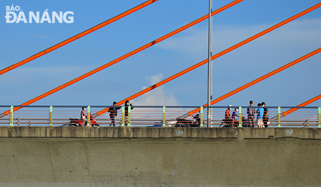 Tuy nhiên, khi văng bóng lực lượng chức năng, thì có khá nhiều người dân dừng, xem và chụp ảnh trên cầu Trần Thị Lý, khi cầu Nguyễn Văn Trỗi nâng. Ảnh: THÀNH LÂN