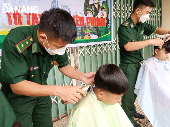 Các cán bộ, chiến sĩ Biên phòng thành phố cắt tóc miễn phí cho trẻ em tại Làng Hy vọng. Ảnh: PHƯƠNG MINH