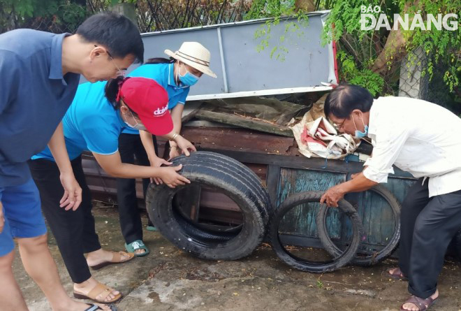  Local residents remove stagnant water, a breeding ground for mosquitoes in a bid to prevent dengue fever.