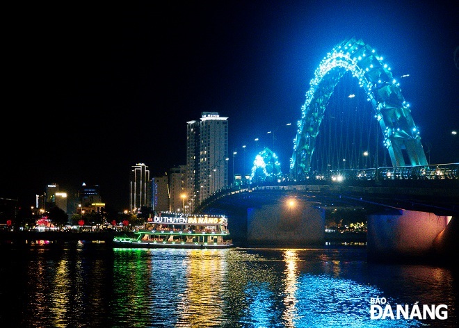A lighted and decorated boat and the Rong (Dragon) Bridge, a symbol of Da Nang.