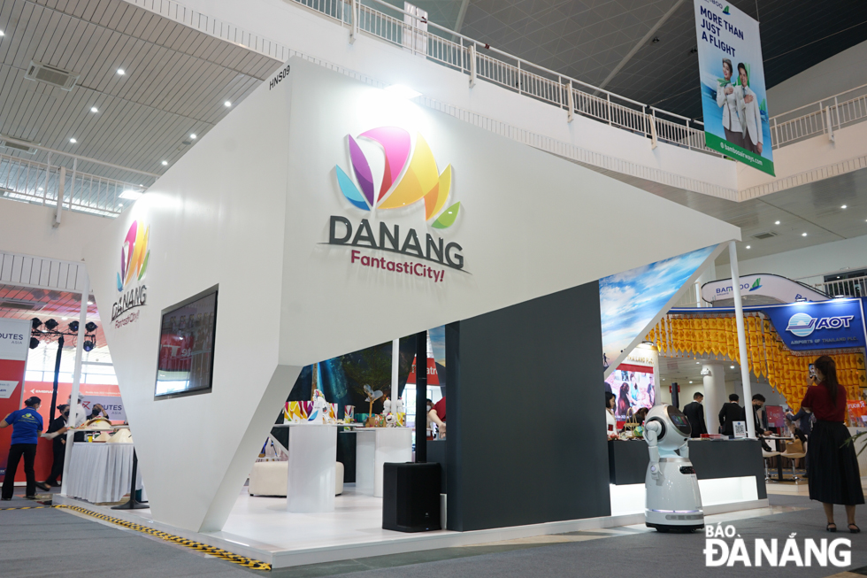  Da Nang's exhibition pavilion is located in the central area, featuring bright white tones and the iconic logo of the city's tourism industry. There is a Danang Fantasticity travel chatbot and an intelligent robot that moves around the pavilion to interact with visitors and for customers to scan QR codes of IPP Travel Retail vouchers.