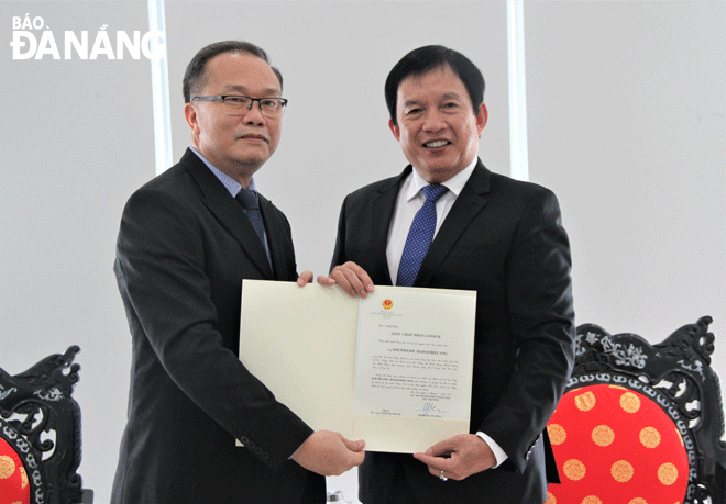 Giám đốc Sở Ngoại vụ Huỳnh Đức Trường (bên phải) tiếp nhận giấy chấp nhận lãnh sự từ ông Souphanh Hadaoheuang, tân Tổng Lãnh sự Lào tại Đà Nẵng. Ảnh: LAM PHƯƠNG