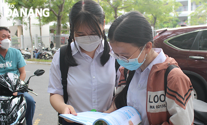 Candidates review the lessons before entering the Chau Trinh Senior High School exam venue. Photo: Huynh Trang