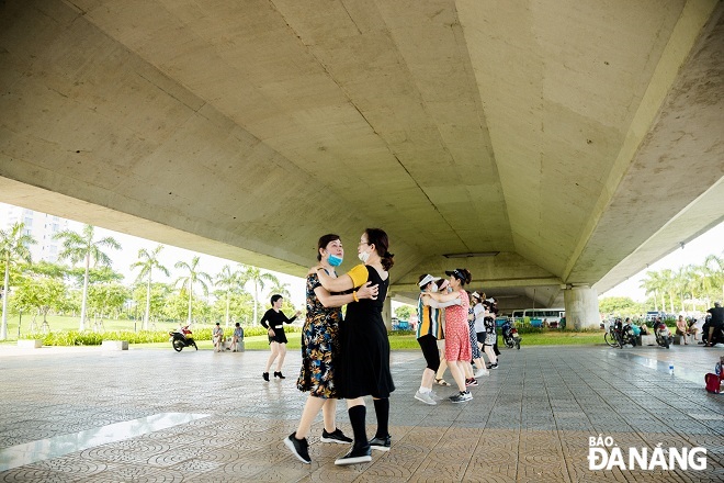 The group of women choose the area under the Tran Thi Ly Bridge as a place to avoid the heat and practice dancing. Photo: CHANH LAM 