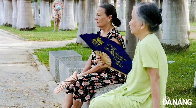 Two elderly women choose the March 29 Park to rest and cool off because this place is lined up with green trees. Photo: CHANH LAM