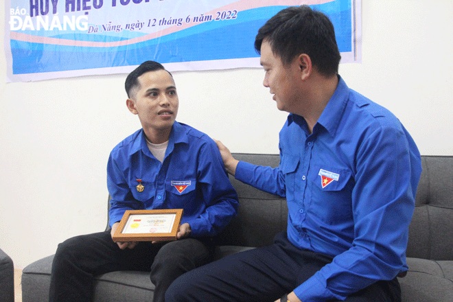 Vice President of the Central Committee of the Viet Nam Students’ Union, Deputy Secretary of the Da Nang Youth Union and President of the Da Nang Students’ Union Le Cong Hung (right) grants the ‘Brave Youth’ badge from the  Central Committee of the Ho Chi Minh Communist Youth Union to Phan Thanh Phu. Photo: NGOC QUOC