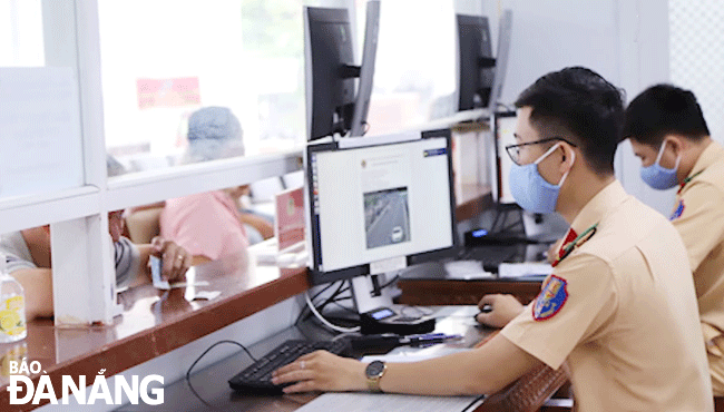 Traffic officers guiding offenders on the procedures for paying fines for breaking the national traffic regulations at the Traffic Police Divison. Photo: THANH LAN