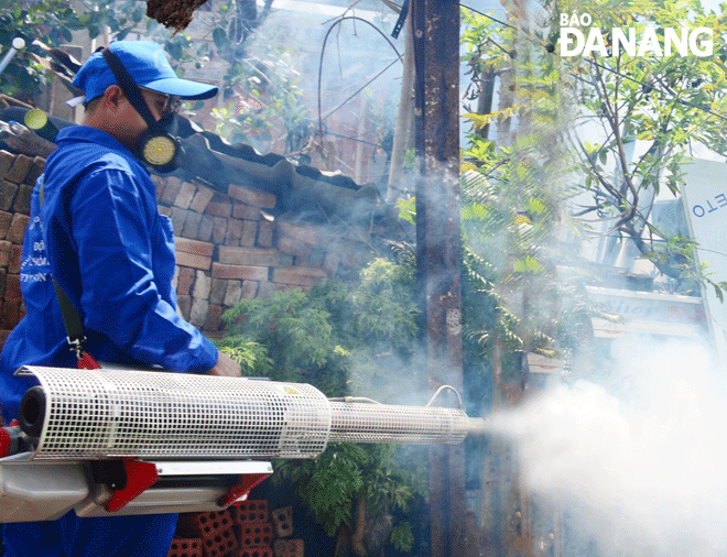 A medical worker in Son Tra District spraying disinfectant to kill mosquito larvae in a bid to prevent dengue fever. Photo: PHAN CHUNG