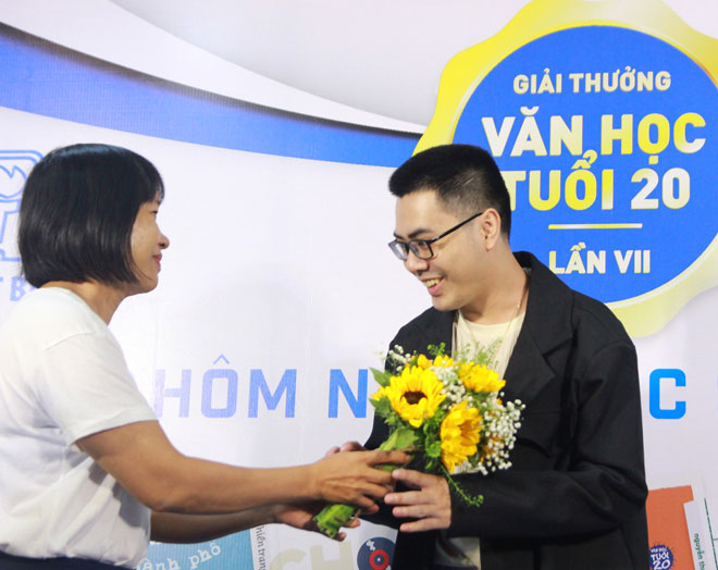 Nhà văn Nguyễn Ngọc Tư (bên trái) tặng hoa chúc mừng tác giả Yang Phan với tập truyện dài “Vụn ký ức” đoạt giải Nhì - Giải thưởng Văn học tuổi 20 lần thứ VII.  (Ảnh do NXB Trẻ cung cấp)