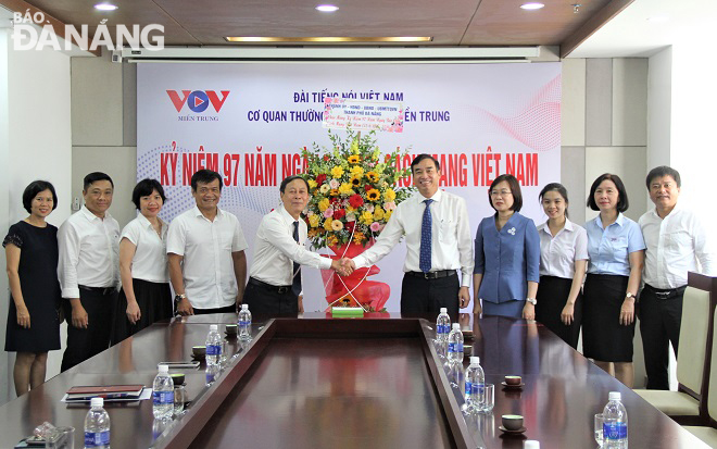 Chủ tịch UBND thành phố Lê Trung Chinh tặng hoa chúc mừng Cơ quan Thường trú Đài tiếng nói Việt Nam tại miền Trung. Ảnh: LAM PHƯƠNG
