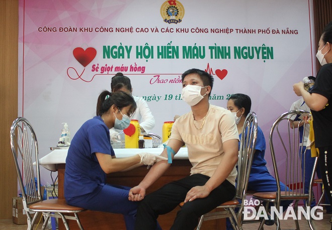A medical worker checking the health status of a voluntary blood donor before blood donation. Photo: X.HAU