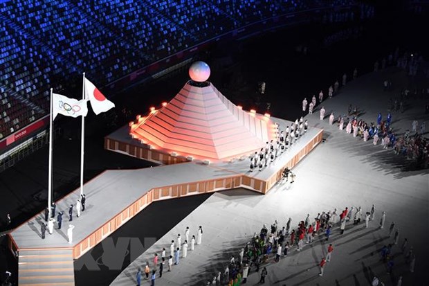 Quốc kỳ Nhật Bản (phải) và cờ Olympic tại lễ khai mạc Olympic Tokyo 2020 ở Tokyo, Nhật Bản, ngày 23-7-2021. (Ảnh: AFP/ TTXVN)