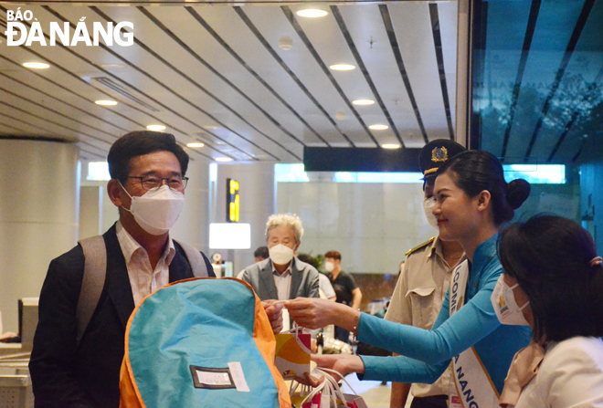 Những vị khách trên chuyến bay đầu tiên từ Incheon (Hàn Quốc) đến Đà Nẵng được chào đón tại sân bay quốc tế Đà Nẵng. Ảnh: THU HÀ.