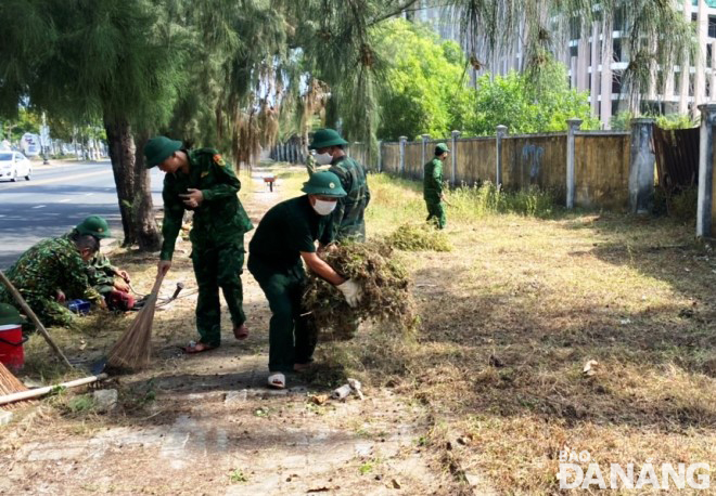 Cán bộ, chiến sĩ Đồn Biên phòng Non Nước tổng dọn vệ sinh trên vỉa hè tuyến đường Trường Sa. Ảnh: HOÀNG HIỆP