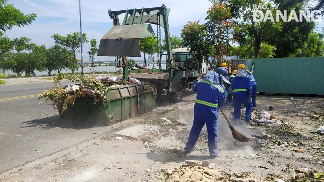 Công nhân Công ty CP Môi trường đô thị Đà Nẵng tổng dọn vệ sinh, thu gom rác trên vỉa hè tuyến đường Võ Chí Công.