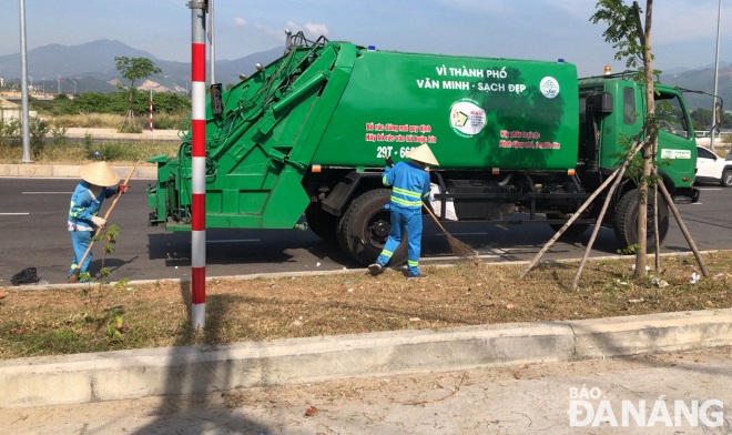 Công nhân Công ty TNHH MTV Môi trường đô thị Hà Nội - Chi nhánh miền Trung tổng dọn vệ sinh trên tuyến đường dẫn đến dự án Bến cảng Liên Chiểu.