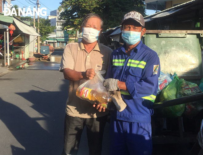 Mr Nguyen Van Day (left) gave gifts to a needy local person. Photo: HONG QUANG