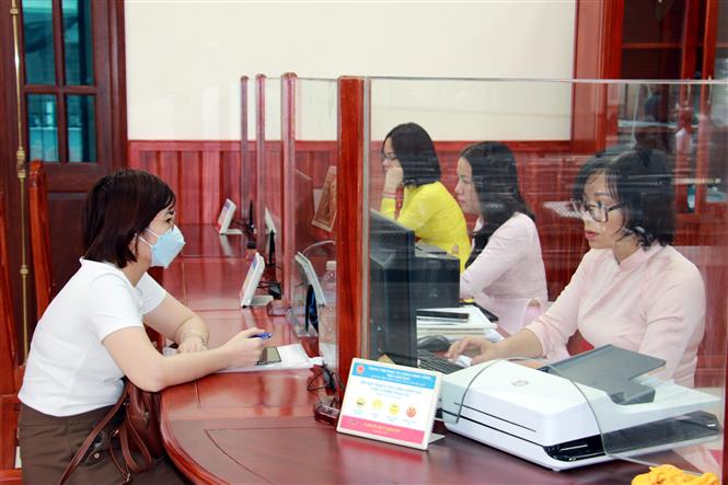 Người dân Nam Định giải quyết các thủ tục hành chính tại Trung tâm phục vụ hành chính công, xúc tiến đầu tư và hỗ trợ doanh nghiệp tỉnh Nam Định. Ảnh: Văn Đạt/TTXVN
