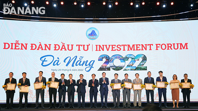 Prime Minister Pham Minh Chinh and Da Nang leaders along with honourees who were chosen for their large investment projects in the city, the completion of their projects ahead of schedule, and their dedication and commitment to the city’s investment promotion activities.