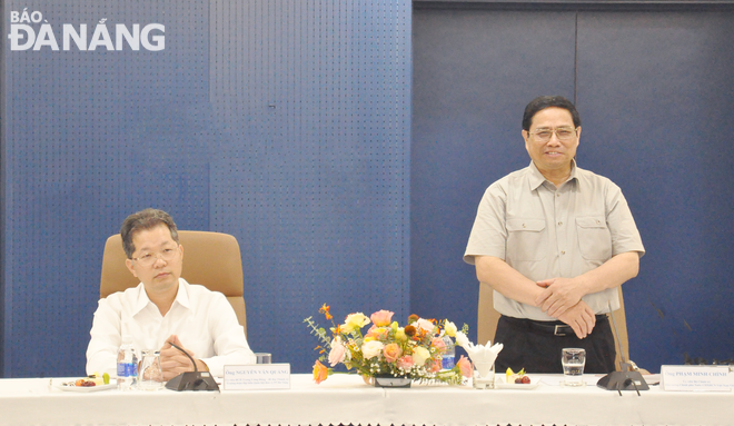 Prime Minister Pham Minh Chinh (right) delivers a keynote speech at a meeting with FPT Corporation representatives 