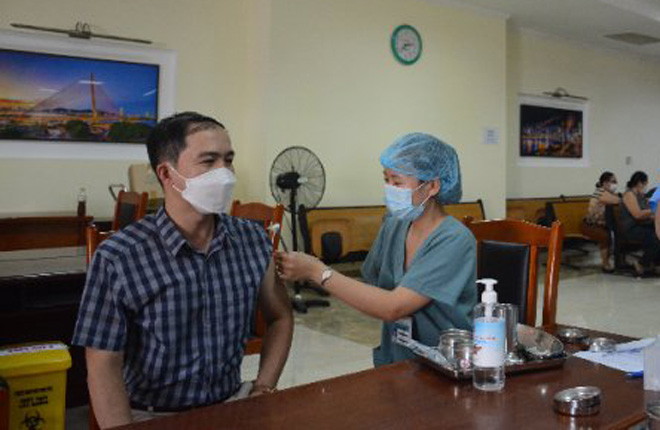 Nhân viên y tế tiêm mũi 4 vắc-xin phòng Covid-19 cho người dân thành phố.  Ảnh: PHAN CHUNG