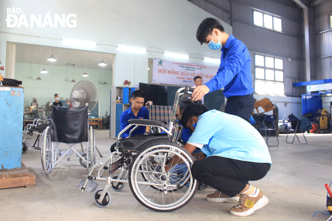 Các sinh viên Trường Cao đẳng nghề Đà Nẵng đang sửa chữa những chiếc xe lăn xuống cấp do Hội Người khuyết tật thành phố gửi đến. Ảnh: HUỲNH TRANG