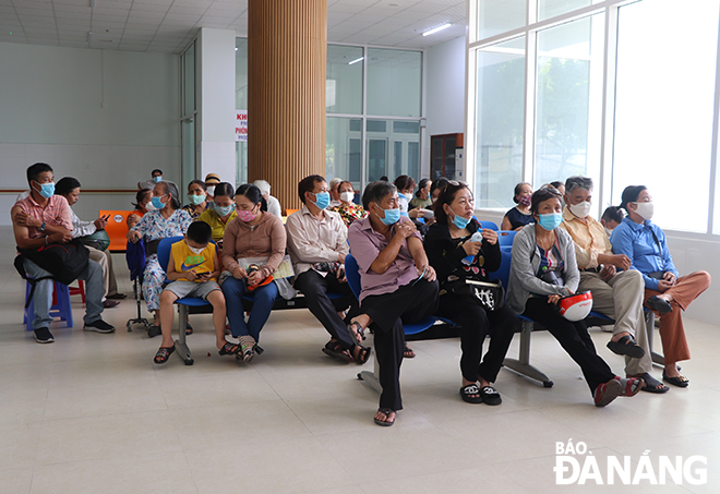 Riêng trong ngày 29-6, có hơn 500 người dân đến điểm tiêm Trung tâm Y tế quận Hải Châu để tiêm vắc-xin mũi 4. Trong ảnh: Người dân ngồi chờ 30 phút sau khi tiêm xong.