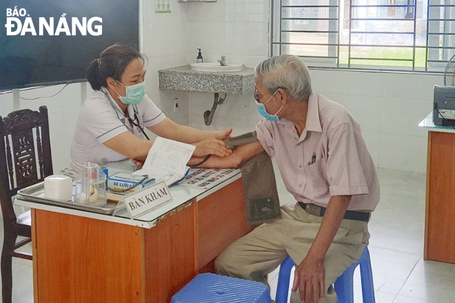 A healthcare professional at Hoa Vang District’s Hoa Tien Commune Medical Station conducting a medical examination for a male senior patient. Photo: PHAN CHUNG