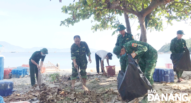 Cán bộ, chiến sĩ Trạm Biên phòng cửa khẩu cảng Tiên Sa thu gom rác tại khu vực bãi biển Tiên Sa (quận Sơn Trà). Ảnh: DOÃN QUANG