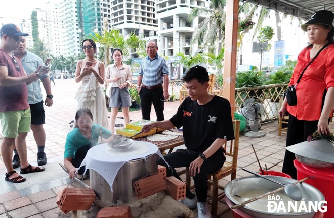  A lot of tourists enjoy spreading the batter onto a cloth that's stretched over a wide pot of boiling water. After the batter has been thinly spread, a bamboo lid covers the rice sheet. A long narrow stick is used to lift and transfer the cooked rice sheet to a cooling 