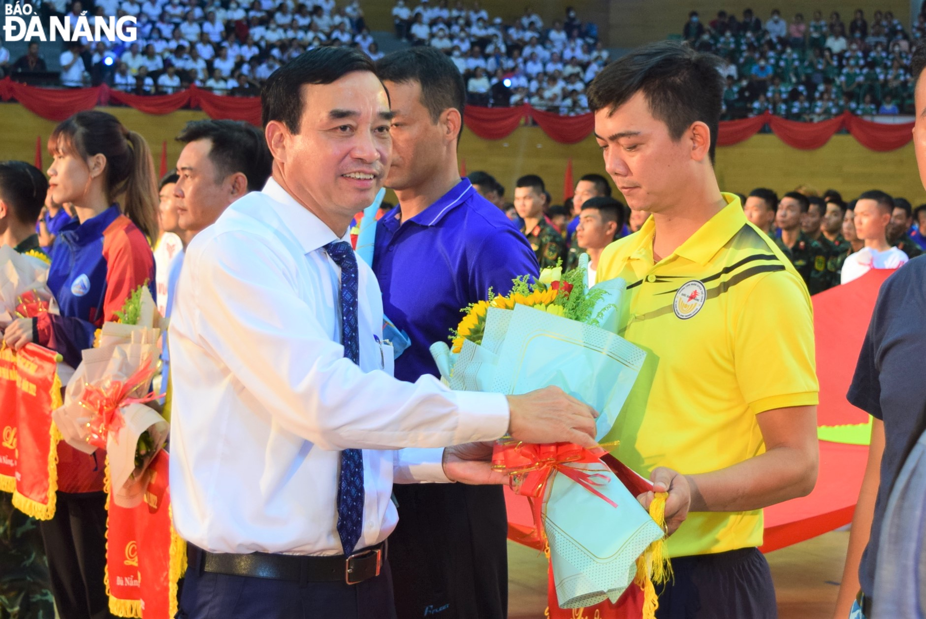 Da Nang Party Committee Deputy Secretary cum municipal People's Committee Chairman Le Trung Chinh giving flowers to participating athletes