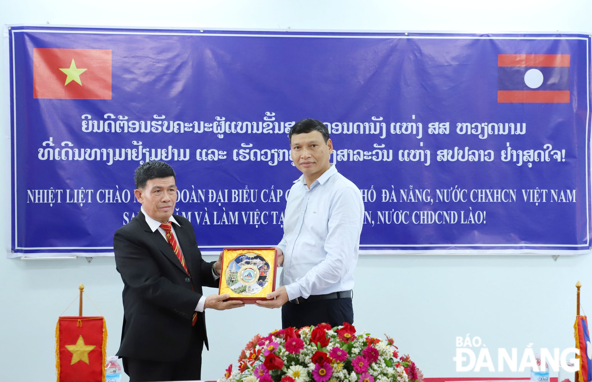 Phó Chủ tịch Thường trực UBND thành phố trao hỗ trợ thiết bị máy tính xách tay, máy tính bảng cho Trung tâm tiếng Việt tỉnh Salavane. Ảnh: NGỌC PHÚ