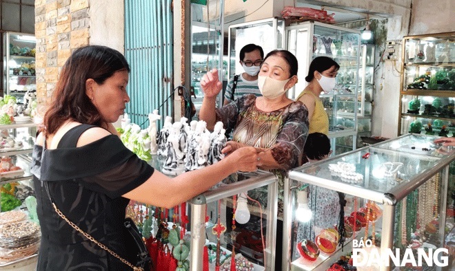 The increasing number of visitors to Da Nang promises a strong recovery of the city's tourism industry. IN PHOTO: Tourists doing shopping at the Marble Mountains Special National-level Relic Site. Photo: THU HA