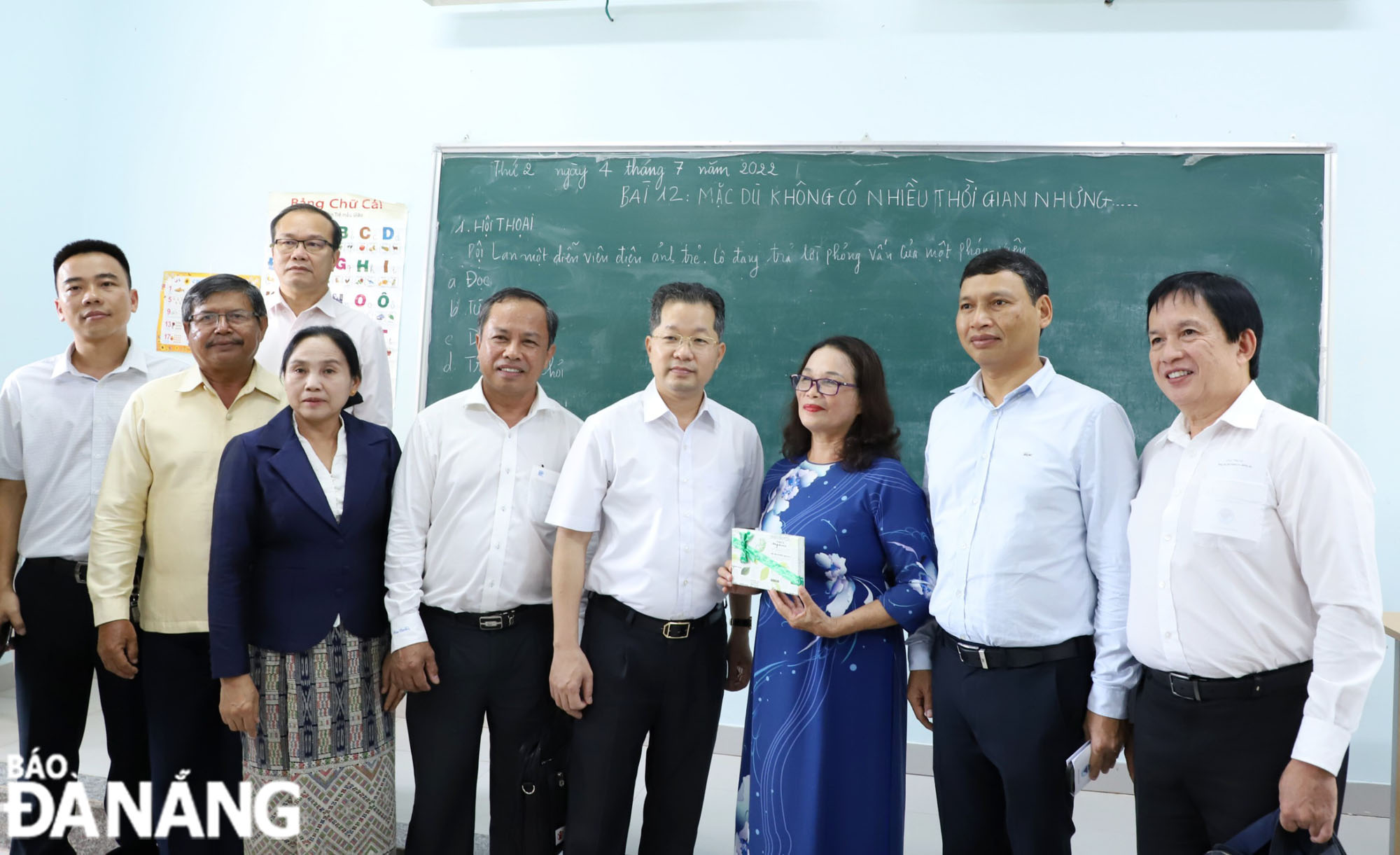 Secretary Quang (fourth, right) and Vice Chairman Minh (second, right) giving gifts to a Da Nang teacher who is teaching at the Vietnamese Language Centre in Salavane Province.