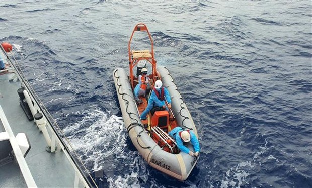 Staff of ship SAR 412 onboard a canoe rush to the rescue of a crew member in distress. (Photo: VNA)