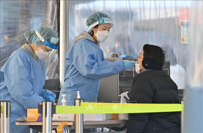 Nhân viên y tế lấy mẫu xét nghiệm Covid-19 cho người dân tại Seoul, Hàn Quốc. Ảnh: AFP/TTXVN