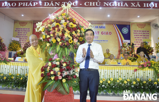 Chủ tịch UBND thành phố Lê Trung Chinh (bên phải) tặng hoa chúc mừng đại hội. Ảnh: T. HUY
