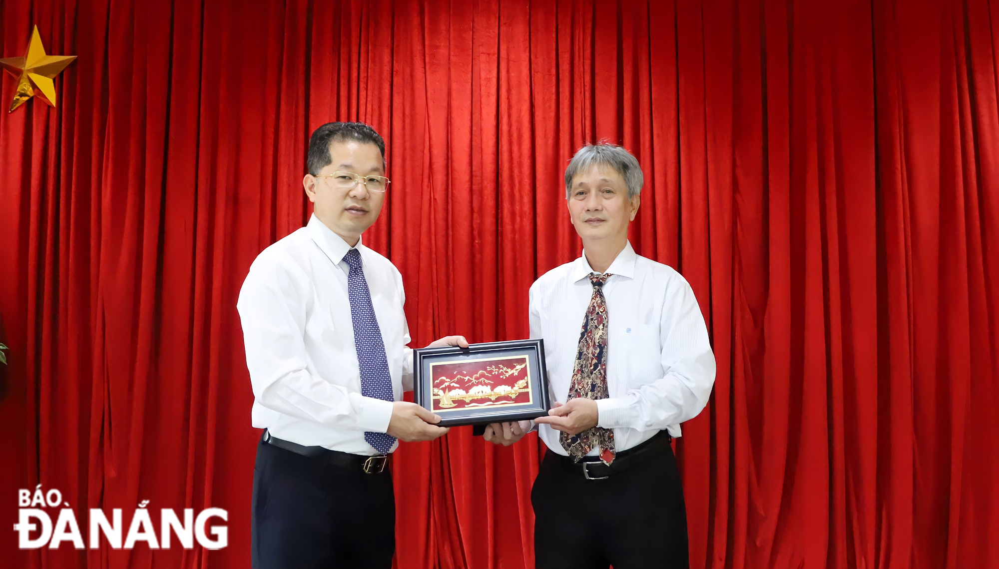 Secretary Nguyen Van Quang (left) presenting a momento to the Vietnamese Consul General in Savannakhet Province. Photo: NGOC PHU