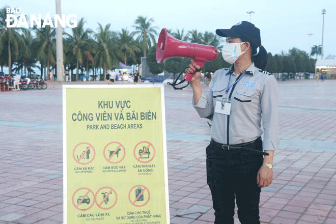 Chị Thái Thị Huyền, nhân viên Đội quản lý trật tự du lịch biển tuyên truyền cho người dân và du khách những điều cấm tại khu vực Công viên Biển Đông. Ảnh: VĂN HOÀNG