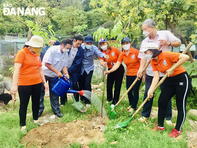 Ông Phạm Hữu Thọ (thứ 3, trái sang) cùng nhân dân trồng cây tạo bóng mát tại khu dân cư. Ảnh: HỒNG QUANG