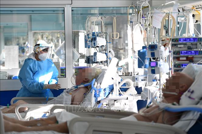 Nhân viên y tế điều trị cho bệnh nhân Covid-19 tại bệnh viện ở Cremona, miền bắc Italy, ngày 11-1-2022. Ảnh: AFP/TTXVN