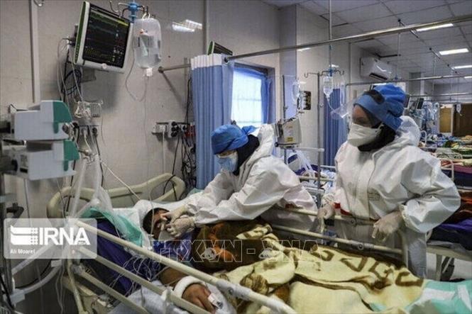 Nhân viên y tế điều trị cho bệnh nhân Covid-19 tại bệnh viện ở Iran. Ảnh: IRNA/TTXVN