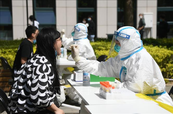 Nhân viên y tế lấy mẫu xét nghiệm Covid-19 cho người dân tại quận Hải Điến, Bắc Kinh (Trung Quốc). Ảnh: THX/TTXVN
